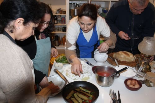 Lezione di cucina collettiva presso Relais Palazzo Cacace a Meta di Sorrento, ospiti che preparano piatti della cucina italiana insieme