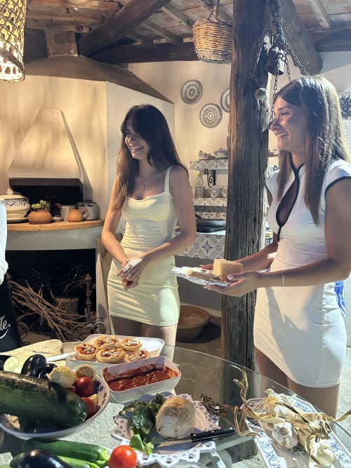 Due donne che gustano cibo e vino al Relais Palazzo Cacace, una affascinante struttura ricettiva a Meta di Sorrento con carattere rustico italiano