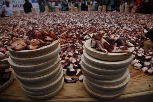 Platos de cerámica apilados con cebollas en Aldea Rural Pazos De Arenteiro, exhibiendo cosecha local y tradición española