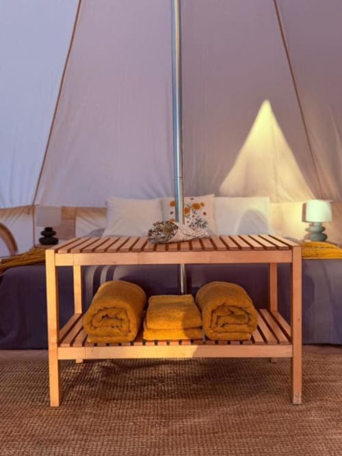 Prateleira de madeira com toalhas enroladas dentro de uma tenda de glamping em Monte da Tojeirinha, Montargil Portugal