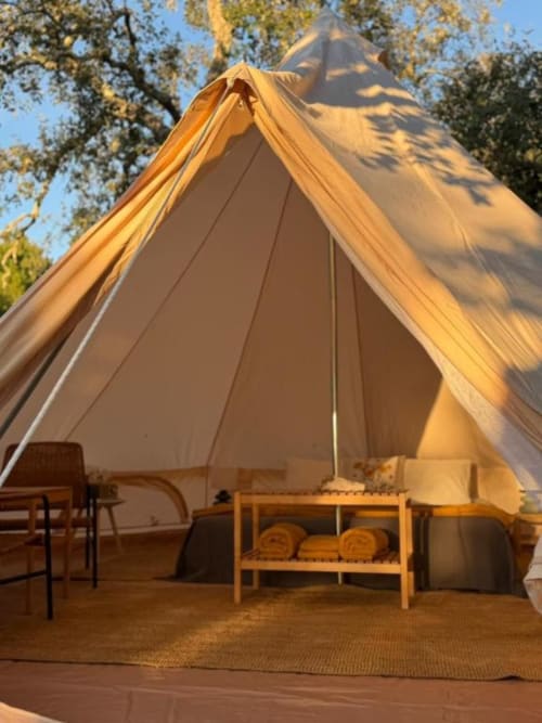 Tenda de glamping na Monte da Tojeirinha em Montargil com móveis em madeira, terraço com vista para lago e floresta