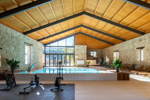 Indoor pool area at El Batán Hotel Spa in Castillo de Locubín with exercise bikes and wooden ceiling