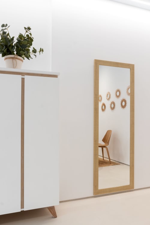Espejo con marco de madera moderna en apartamento de Gandía con planta en maceta y decoración minimalista