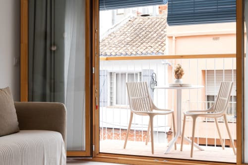 Balcón de apartamento en Ona vacaciones Gandía con tumbonas modernas, mesa y vistas al solárium costero