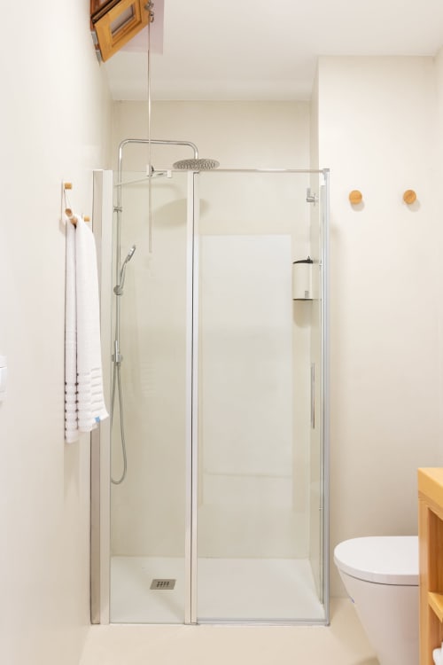Baño moderno con ducha a ras de suelo, alcachofa de lluvia y inodoro blanco en el apartamento Ona Vacaciones de Gandía