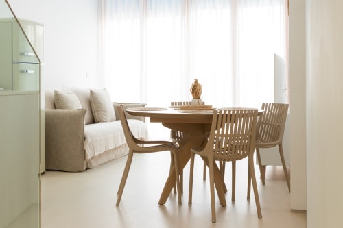 Luminoso comedor con mesa de madera, sillas naturales y sofá beige en el dúplex Ona vacaciones de Gandía