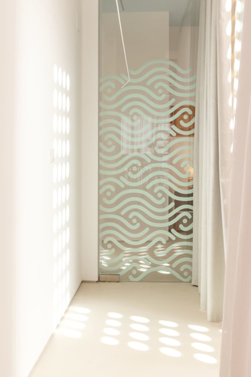 Luminoso pasillo con puerta de cristal con patrón ondulado decorativo en duplex del hotel Ona vacaciones Gandía
