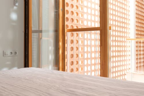 Luminosa habitación dúplex en Ona Vacaciones Gandía con vistas a fachada de ladrillo terracota y ventanas de marco de madera con vista a la piscina