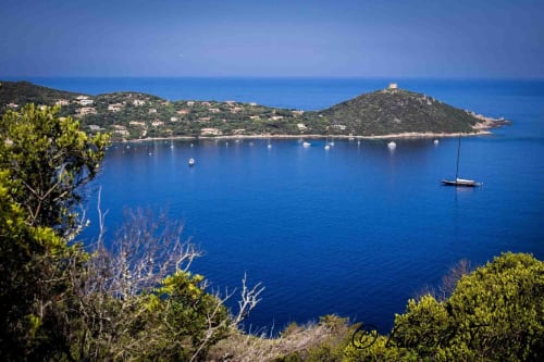 Baie méditerranéenne près de Propriano avec voiliers, maisons sur les hauteurs et eaux turquoise