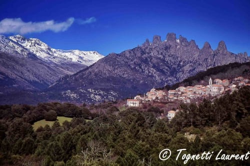 Village corse niché dans les montagnes aux pics enneigés et forêts denses entourant Propriano