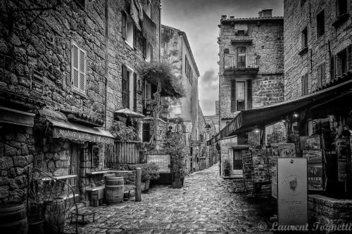 Charmante rue médiévale pavée de pierre à Propriano avec boutiques rustiques et bâtiments couverts de lierre