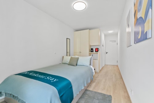 Chambre moderne chez Mattbnb à Metz avec lit queen-size, penderie intégrée et tableau vue sur la ville