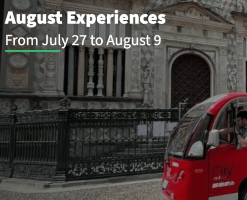 Autobus rosso in una strada di Bergamo con edificio storico e cancellata in ferro al The Kraken Inn
