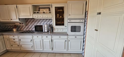 Cuisine blanche avec carrelage géométrique, électroménagers et armoires dans la villa Mi Casa Es Su Casa