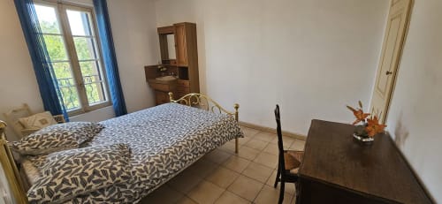 Chambre de la villa La Casa Familiar à Carcassonne avec lit, bureau en bois, armoire miroir et vue sur la ville