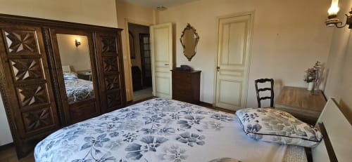 Chambre spacieuse à la villa La Casa Familiar à Carcassonne avec armoire ornementale et literie fleurie