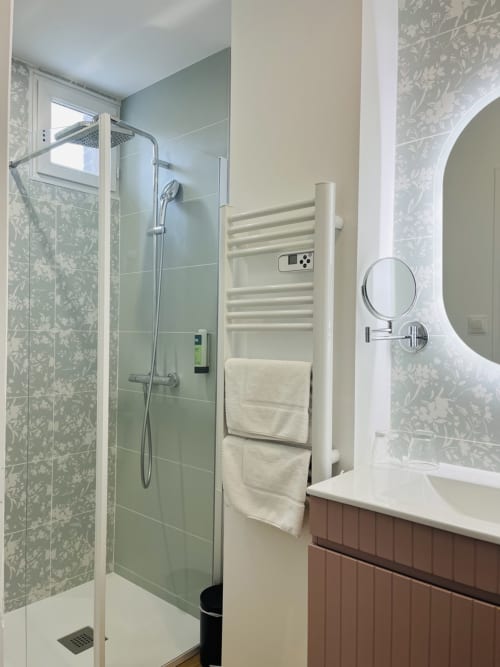 Modern bathroom at Le Clos Normand with rainfall shower, heated towel rack, and vanity mirror in Cosy room