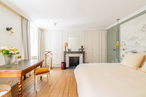 Chambre élégante du Domaine by A&G à Vendrest avec cheminée, parquet et mobilier crème
