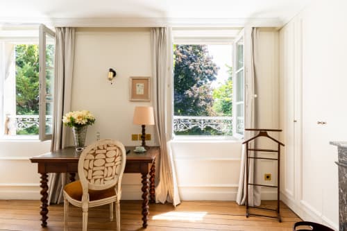 Élégant espace de travail en chambre au domaine by A&G, Vendrest, avec bureau, chaise et vue sur le jardin par portes-fenêtres