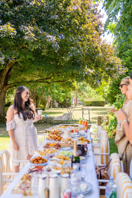 Réception en jardin au Domaine by A&G à Vendrest, France, avec des convives savourant un élégant banquet à table longue en plein air
