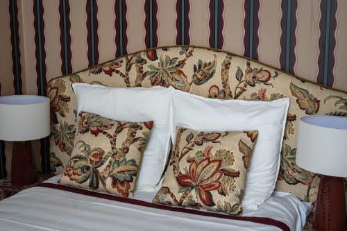 Chambre élégante de la villa DeauvHills à Deauville avec tête de lit motifs floraux, oreillers blancs et coussins décoratifsDeauville avec tête de lit à motifs floraux, oreillers blancs et coussins décoratifsuits