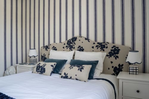 Chambre élégante à la Villa DeauvHills avec tête de lit à motifs floraux, papier peint rayé et accents bleu marine