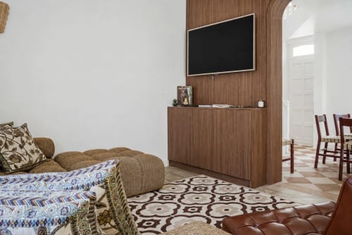 Salon moderne de villa aux DEAUV HILLS avec TV murale, lambris bois, canapé beige et tapis géométrique