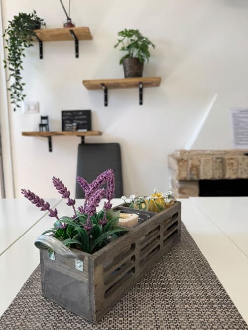 Cassetta rustica in legno con lavanda viola e succulente su tappeto texture, scaffali in legno con piante su parete bianca
