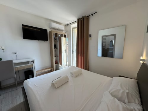 Camera moderna dell'Hotel Queen Sissi a Campofilone con TV a schermo piatto, aria condizionata e arredi contemporanei