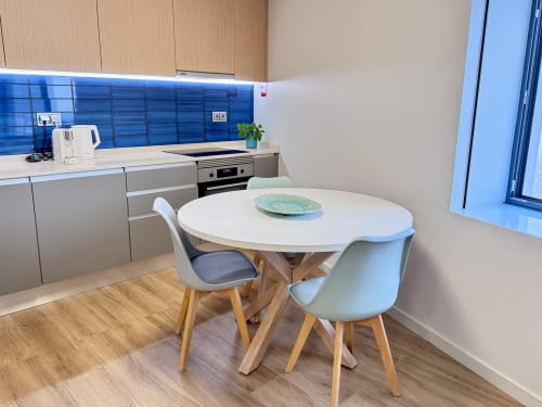 Cuisine-séjour moderne dans l'appartement Twin Turquoise à RIA CENTRUM Smart Residence, Aveiro, avec table ronde blanche et bleue