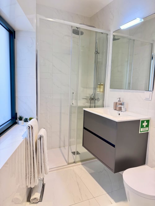 Salle de bain moderne du RIA CENTRUM Smart Residence à Aveiro avec douche à l'italienne, meuble vasque anthracite et carrelage imitation marbre