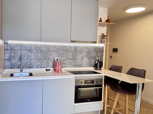 Cuisine moderne grise à l'appartement RIA CENTRUM Smart Residence Aveiro avec électroménagers inoxydables et dosseret à motifs