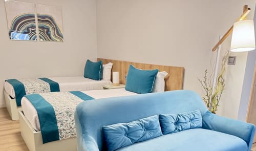 Chambre Twin Turquoise à la RIA CENTRUM Smart Residence d'Aveiro avec deux lits simples, canapé bleu et mobilier moderne