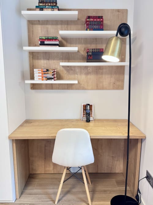 Espace de travail moderne avec bureau en bois, étagères blanches remplies de livres, lampe en laiton et chaise blanche à RIA CENTRUM Smart Residence