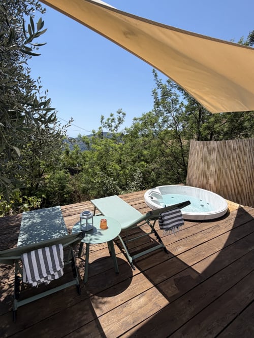 Private terrace with hot tub and loungers at Agritusmo Stecadò in Dolceacqua, overlooking gardens