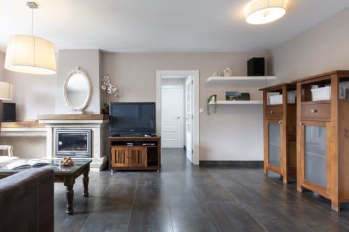 Moderno salón en casa rural de Vilaboa, Pontevedra, con chimenea, televisor, muebles de madera y vistas a las montañas