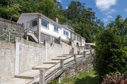Casa rural Vilaboa en Pontevedra con terrazas de piedra, fachada blanca moderna, vistas a la montaña y vegetación exuberante