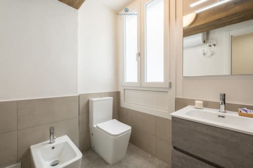 Bagno moderno presso House Live Express Cagliari con wc, bidet, lavandino, specchio e finestra