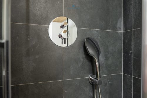 Moderni rubinetti per doccia su piastrelle grigio scuro nel bagno dell'appartamento House Live Express, Cagliari