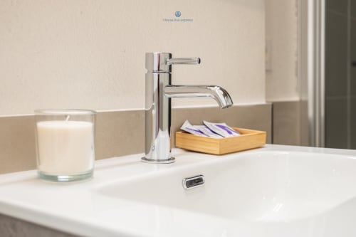 Lavabo moderno con rubinetto cromato, candela e portaccessori in legno presso House Live Express, Cagliari