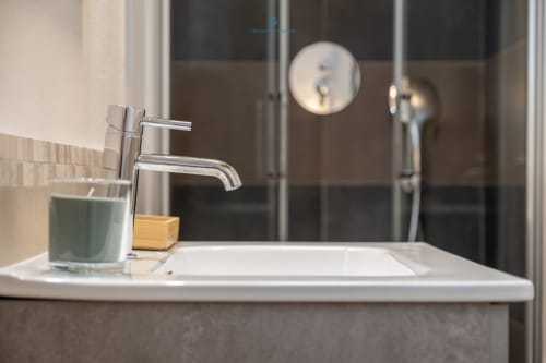 Moderno lavabo del bagno con rubinetto cromato presso House Live Express, appartamento a Cagliari con vista sul giardino