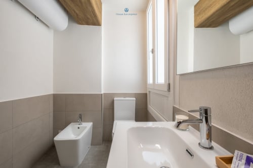 Bagno moderno nell'appartamento House Live Express a Cagliari con sanitari bianchi, bidet, WC e rubinetto cromato