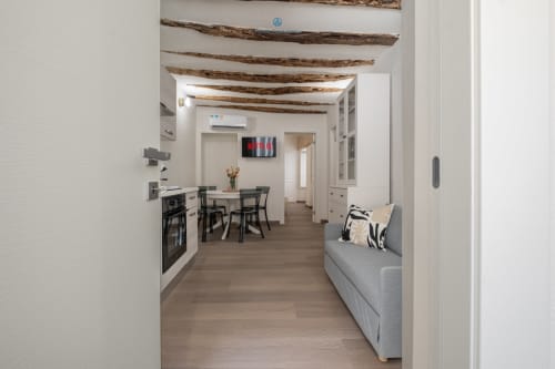 Appartamento moderno House Live Express Cagliari con cucina a vista, zona pranzo e soggiorno con travi in legno a vista