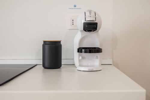 Macchina da caffè DeLonghi bianca con serbatoio nero presso l'apartment House Live Express a Cagliari