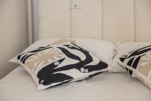 Camera da letto moderna con cuscini decorativi a motivi bianco e nero su letto bianco presso House Live Express, appartamento a Cagliari