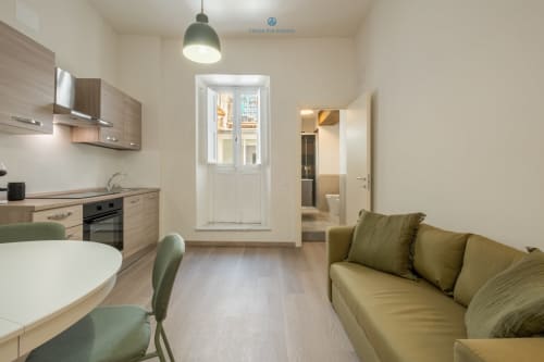Moderno appartamento a Cagliari con cucina a vista, sala da pranzo e divano tortora con vista sulla città