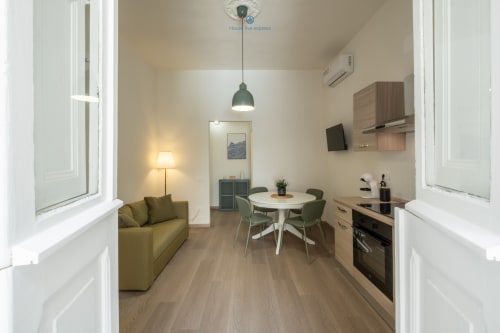 Moderno appartamento presso House Live Express a Cagliari con cucina a vista, zona pranzo e soggiorno con divano