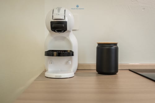 Macchina da caffè espresso bianca con portacapsule nero e tazza presso l'appartamento House Live Express a Cagliari