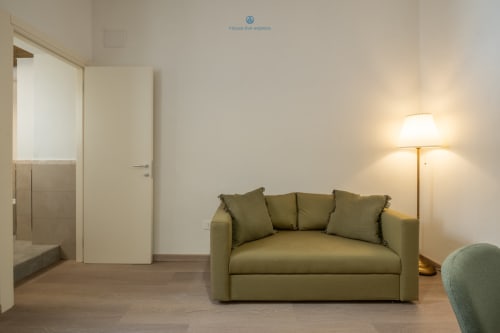 Divano verde oliva moderno in soggiorno minimalista presso House Live Express, Cagliari