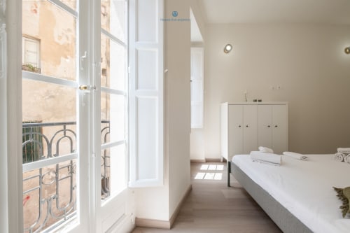 Camera luminosa in appartamento House Live Express a Cagliari, con vista balcone, letto, guardaroba e comfort moderni